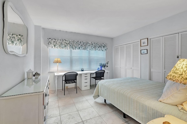 bedroom with multiple closets and light tile patterned floors