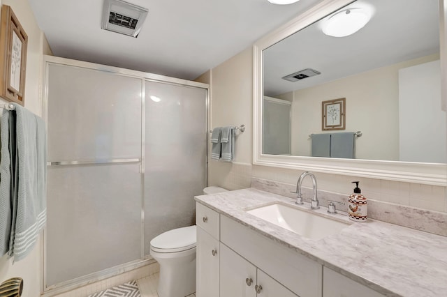 bathroom featuring visible vents, a stall shower, toilet, and vanity