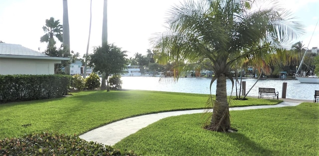 view of property's community featuring a lawn and a water view