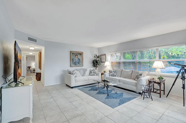 living area featuring baseboards, light tile patterned flooring, and visible vents