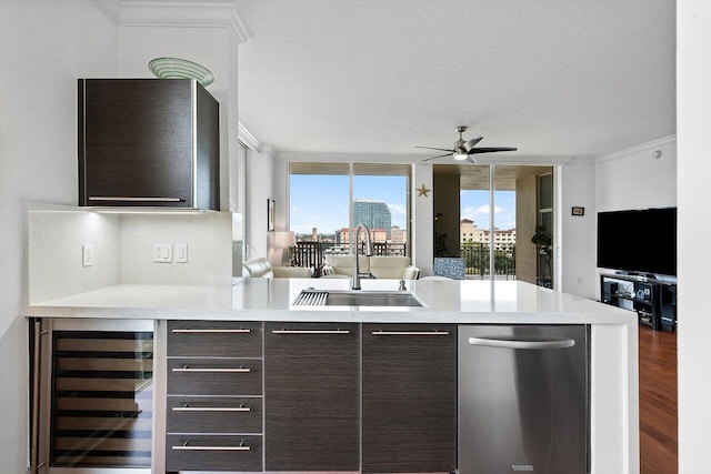 kitchen featuring sink, a textured ceiling, beverage cooler, and dark brown cabinets