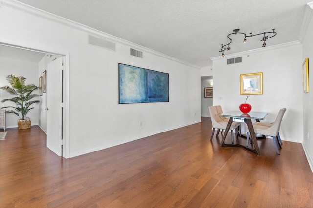 dining room with dark hardwood / wood-style floors, a textured ceiling, and ornamental molding