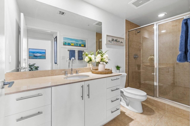 bathroom with vanity, toilet, a shower with shower door, and tile patterned flooring