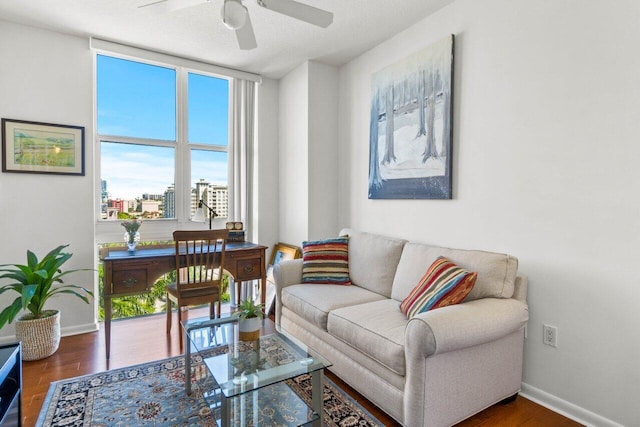 living room featuring ceiling fan and dark hardwood / wood-style flooring