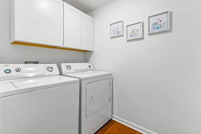 washroom featuring cabinets, separate washer and dryer, and dark hardwood / wood-style floors