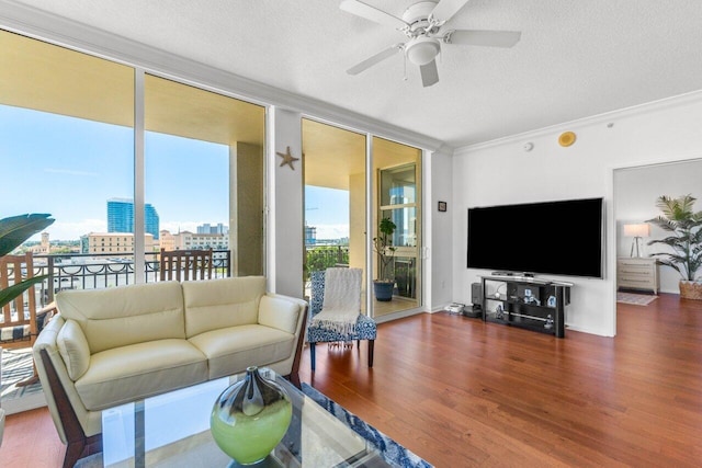 living room with dark wood-type flooring, a wealth of natural light, and crown molding