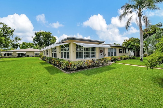 rear view of property with a lawn