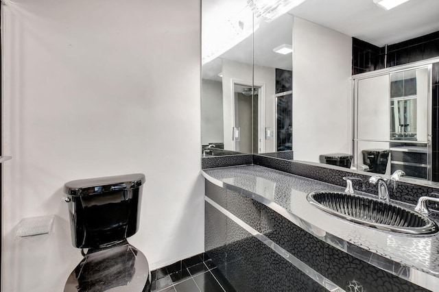 bathroom featuring walk in shower, vanity, toilet, and tile patterned floors