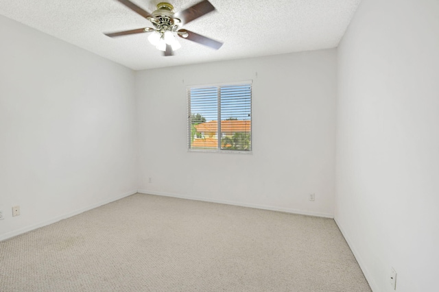 empty room featuring a textured ceiling, ceiling fan, and light colored carpet