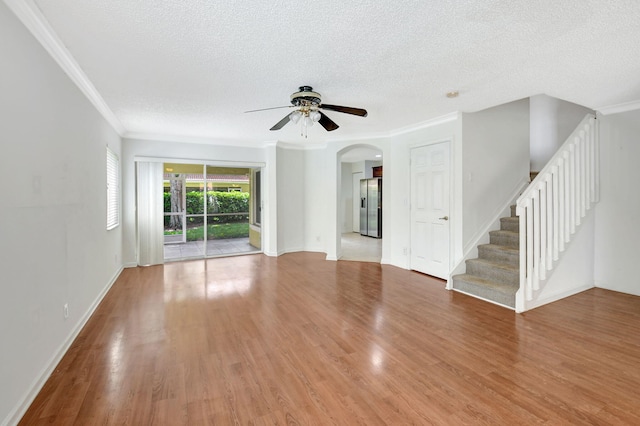 unfurnished living room featuring a textured ceiling, ornamental molding, ceiling fan, and light hardwood / wood-style flooring