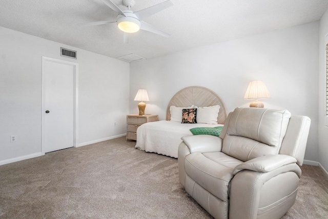 carpeted bedroom with ceiling fan and a textured ceiling