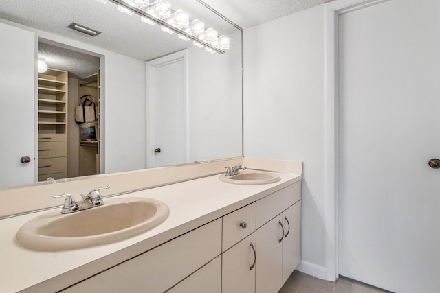 bathroom featuring vanity, a textured ceiling, and tile patterned flooring