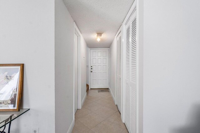 hall featuring a textured ceiling