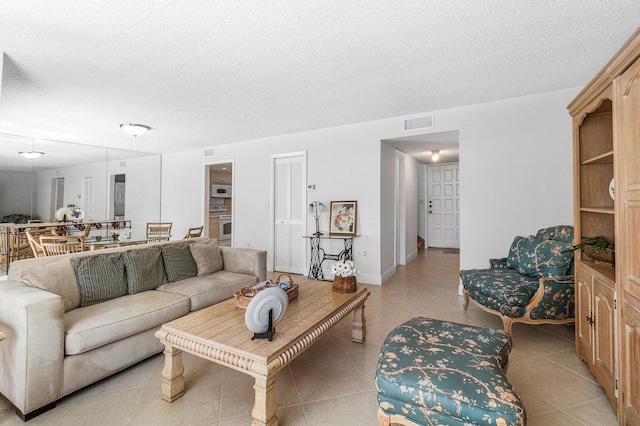 living room featuring a textured ceiling and light tile patterned flooring