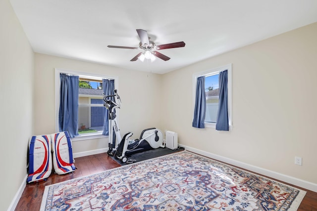 workout room featuring ceiling fan, dark hardwood / wood-style floors, and a healthy amount of sunlight