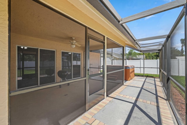 unfurnished sunroom with ceiling fan