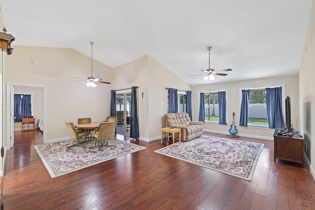 living room with dark hardwood / wood-style flooring, ceiling fan, and high vaulted ceiling