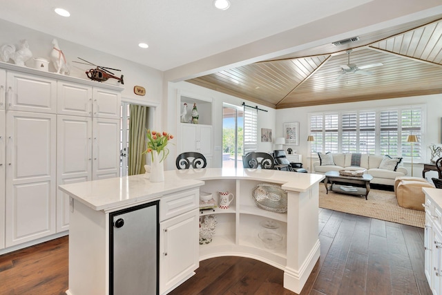 kitchen with white cabinets, ceiling fan, and a center island