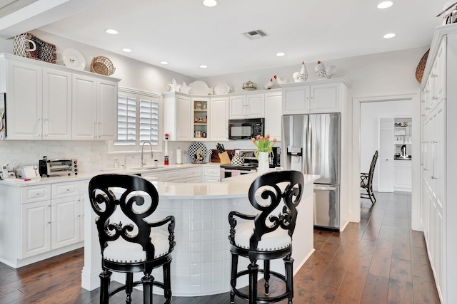 kitchen featuring stainless steel appliances, white cabinets, and dark wood-type flooring