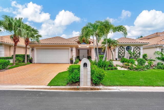 mediterranean / spanish home featuring a front yard and a garage