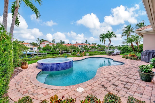 view of swimming pool featuring an in ground hot tub and a patio area