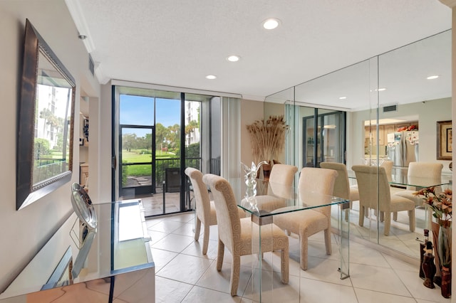 tiled dining room with a textured ceiling, crown molding, and floor to ceiling windows