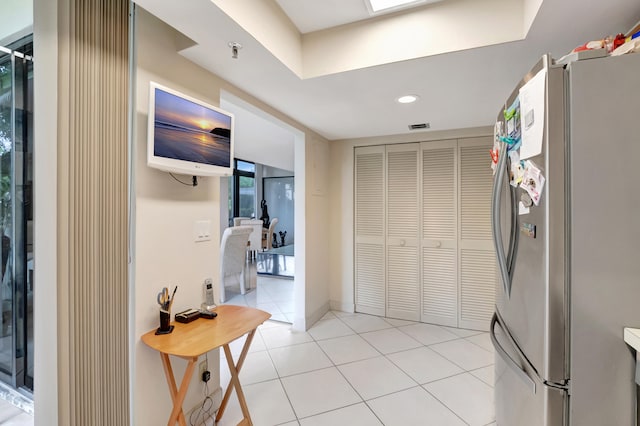 kitchen featuring light tile patterned flooring and stainless steel fridge