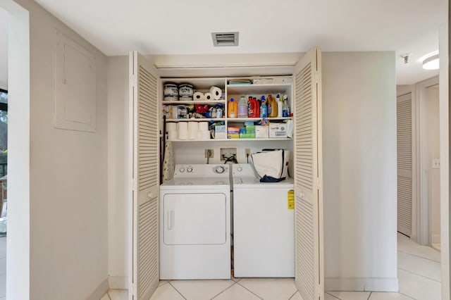 laundry area featuring light tile patterned floors, electric panel, and independent washer and dryer