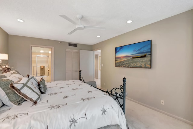 carpeted bedroom with ceiling fan, a textured ceiling, and ensuite bath