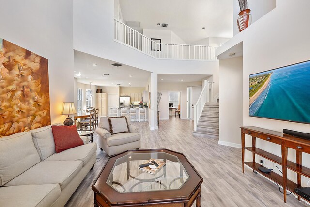 living room with a high ceiling and light wood-type flooring