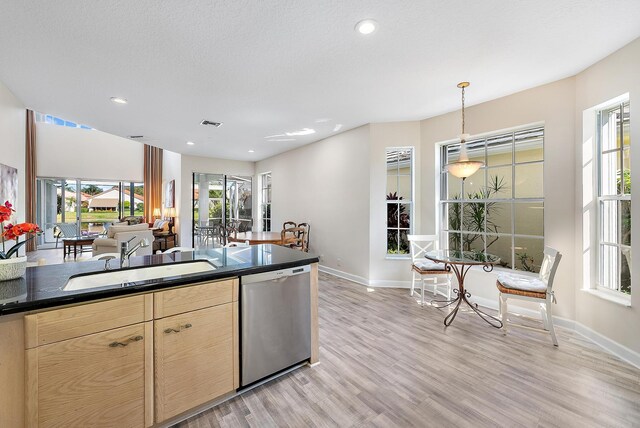 kitchen with dishwasher, light hardwood / wood-style floors, sink, decorative light fixtures, and light brown cabinetry