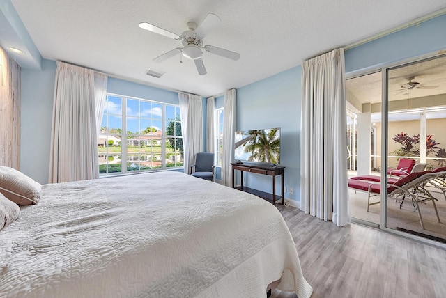 bedroom with ceiling fan, a textured ceiling, and light hardwood / wood-style floors