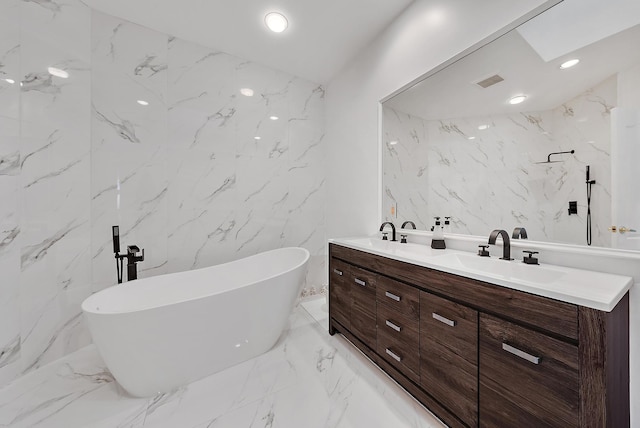 bathroom featuring tile walls, vanity, and a washtub