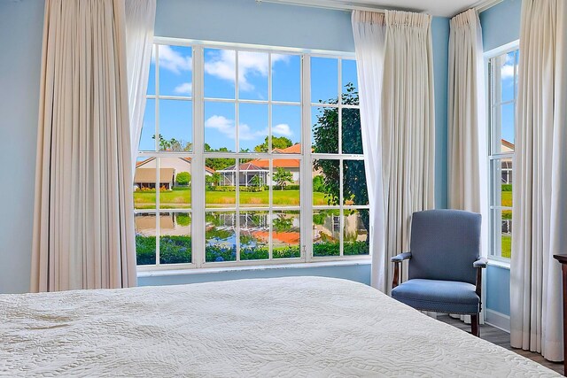 bedroom with multiple windows and hardwood / wood-style floors