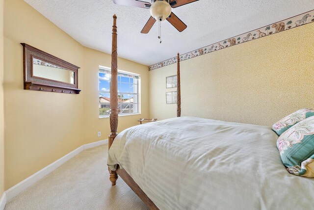 carpeted bedroom featuring a textured ceiling and ceiling fan