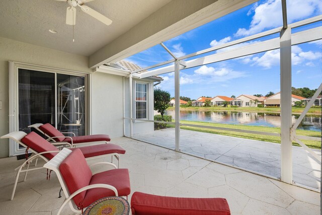 sunroom with a water view, ceiling fan, and plenty of natural light