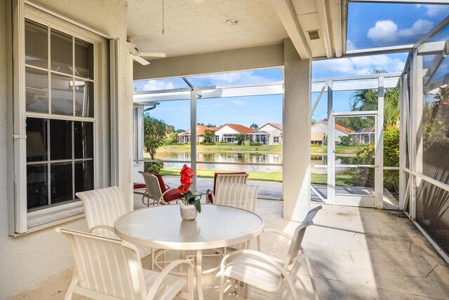 sunroom / solarium with a water view and ceiling fan