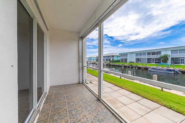 unfurnished sunroom featuring a water view