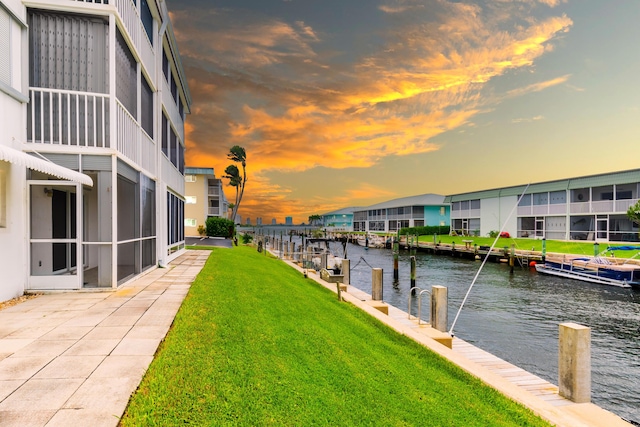 dock area with a water view and a yard