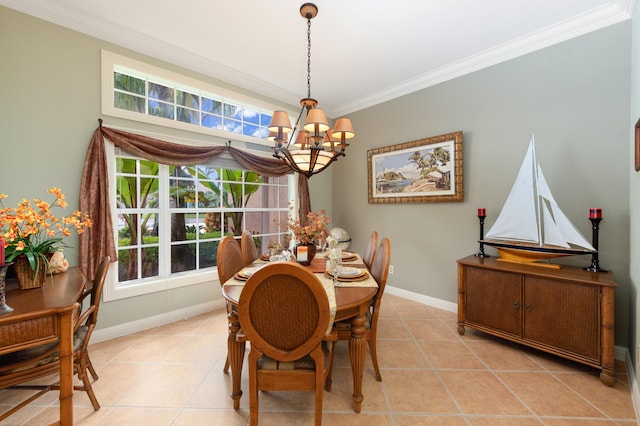 dining space with an inviting chandelier, light tile patterned floors, baseboards, and crown molding