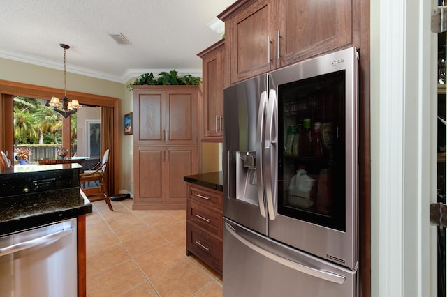 kitchen with pendant lighting, crown molding, light tile patterned floors, appliances with stainless steel finishes, and dark stone counters