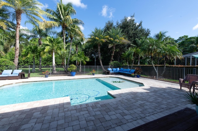 view of swimming pool featuring a patio area, fence, an outdoor living space, and a fenced in pool