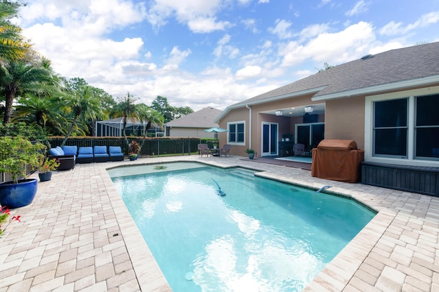 view of pool with fence, an outdoor living space, grilling area, a fenced in pool, and a patio area