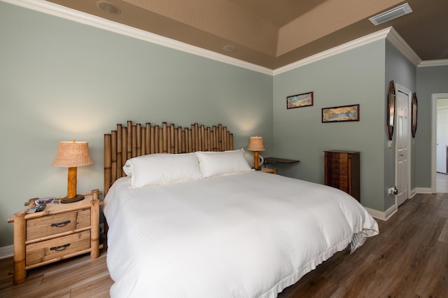 bedroom featuring dark wood-style flooring, visible vents, crown molding, and baseboards