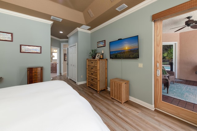 bedroom featuring light wood finished floors, baseboards, visible vents, and crown molding