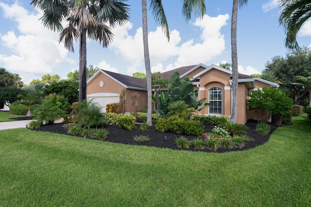 view of front of property with a garage, a front yard, and stucco siding