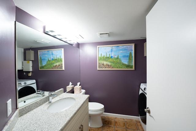 bathroom with washer / clothes dryer, tile patterned flooring, toilet, and vanity