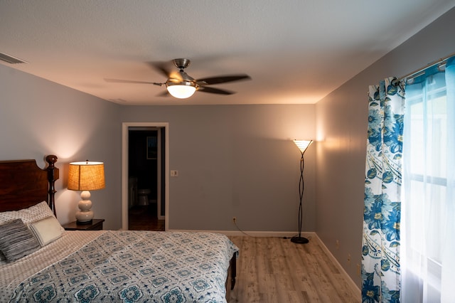 bedroom featuring a textured ceiling, wood-type flooring, and ceiling fan