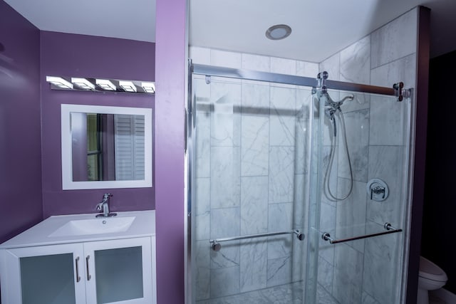 bathroom featuring vanity, toilet, and a shower with shower door