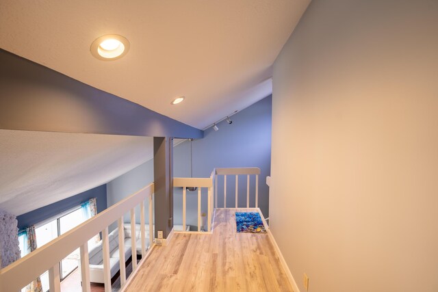 hallway featuring lofted ceiling and hardwood / wood-style floors